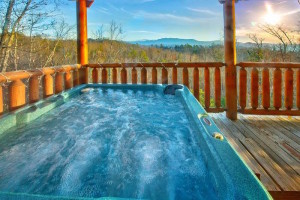 Hot tub on the deck of a Gatlinburg TN cabin rental with a scenic mountain view.