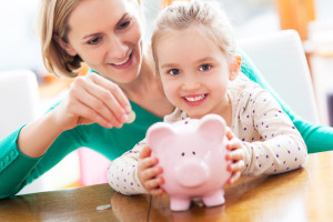 Mother and daughter saving money in a piggy bank