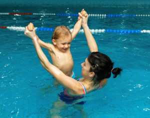 Mother playing with son in indoor pool