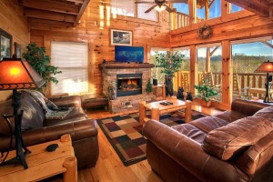 The beautiful family room of a Gatlinburg TN cabin rental with a fireplace and flatscreen TV.